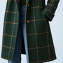 Manteau vert à carreaux — détail du bouton et de la poche