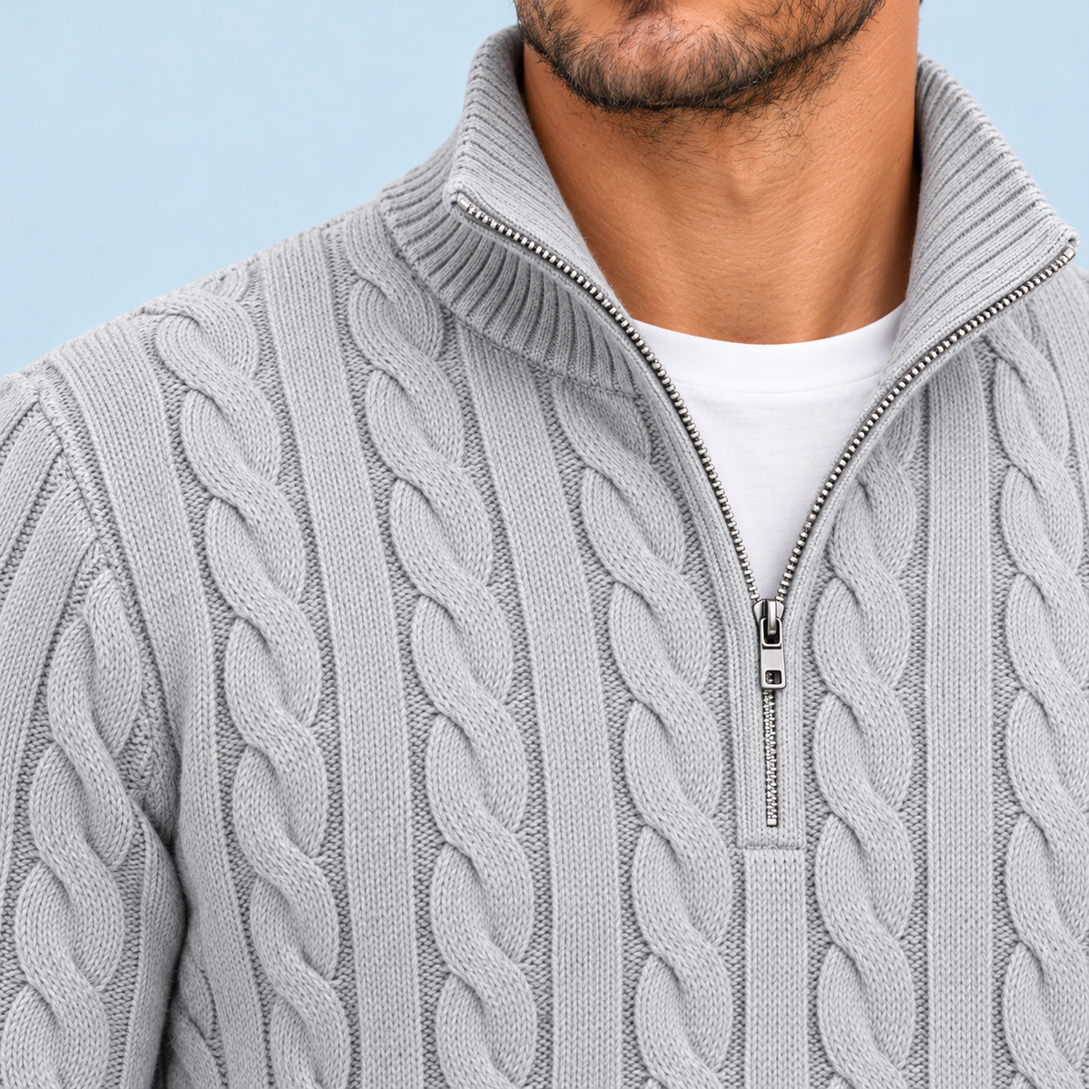 Détail du col montant, du zip et de la maille torsadée du pull gris